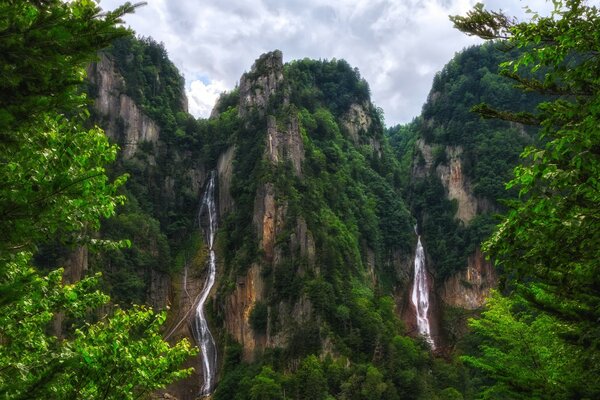 Montañas con vegetación densa y cascada