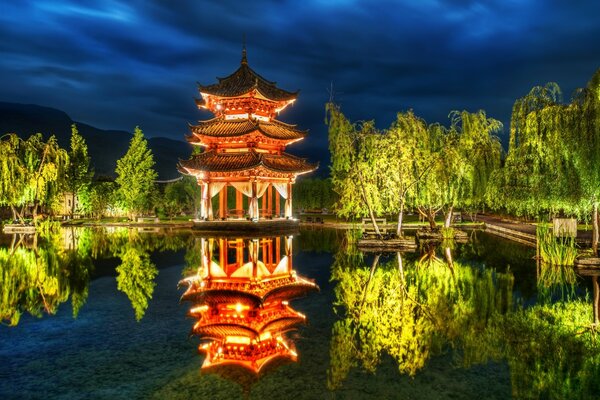 Night landscape. The pagoda is reflected in the lake