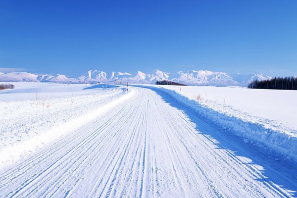 The snow-covered road stretches into the distance