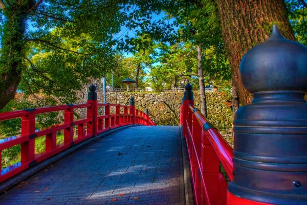 Red bridge with stone paving stones in the park