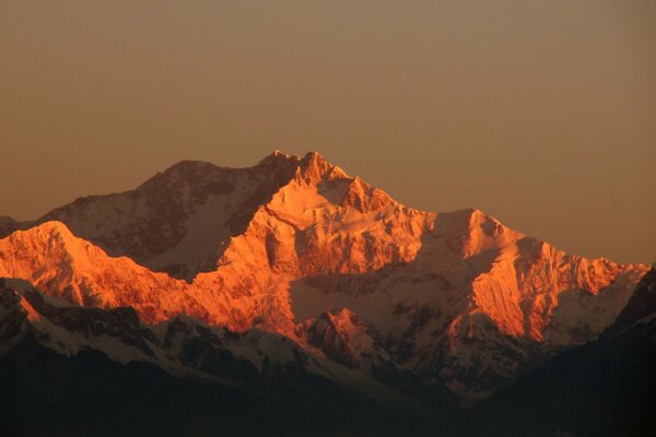 Montagnes enneigées rouillées à la lumière des rayons du soleil