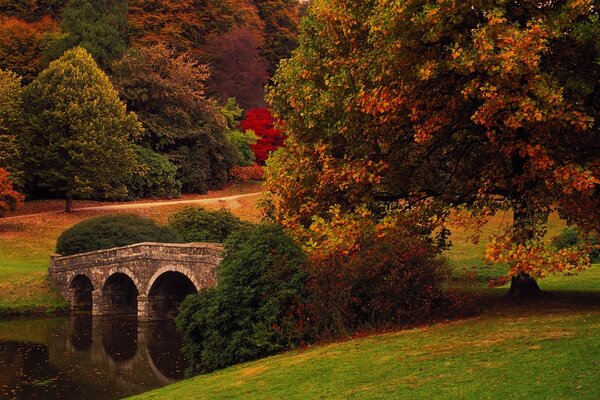 Alte Steinbrücke über den Fluss im europäischen Outback, herbstliche Landschaft