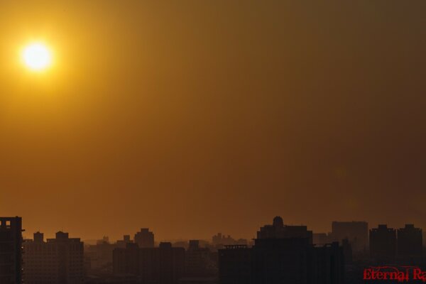 The suns haze over the skyscrapers of the modern city