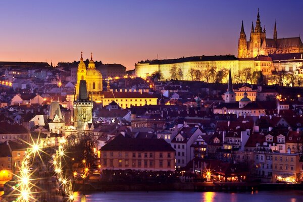 A European city illuminated by night lights under a twilight sky