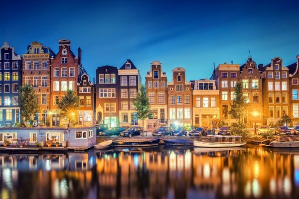 Evening photo of houses by the river with boats