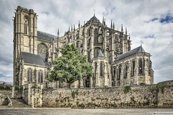 The Gothic building stands against the background of clouds