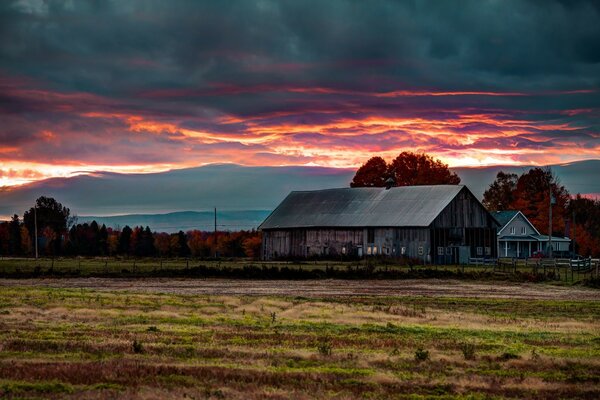 Evening village. Thunderclouds. Sunset