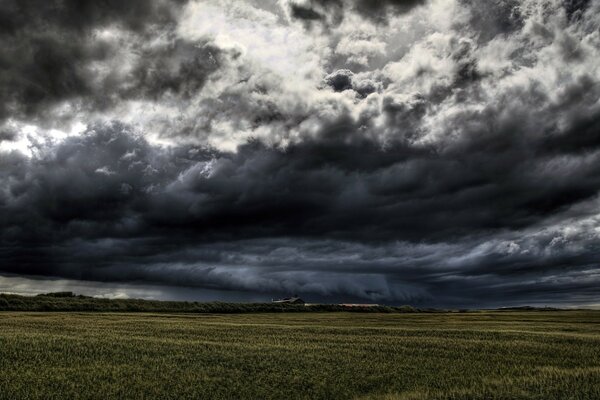 Schwarze, faszinierende Wolken über dem Feld