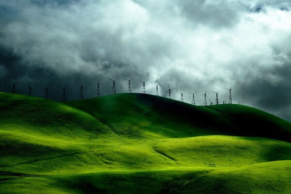 Heavy thunder clouds. Hills and meadows. Wind farms