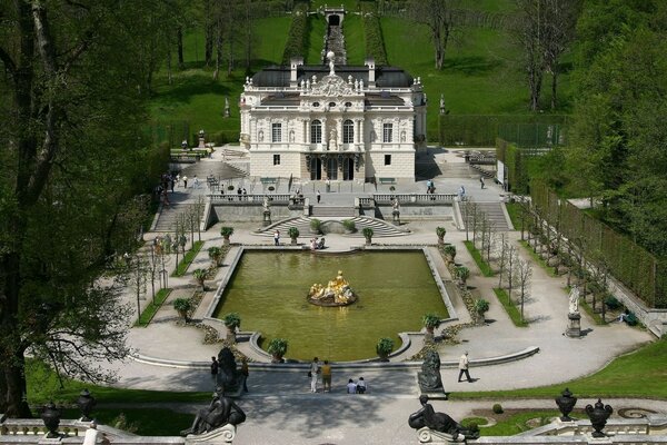 A luxurious palace with a park and a pond