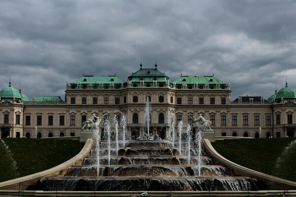 Fountains on the background of a castle in a thunderstorm