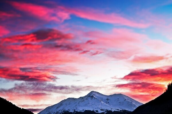 The sky covered with crimson clouds in the mountains leads to a strong wind