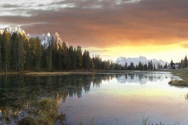 Dawn on the background of the lake, mountains and forests. The joy of the mountains in the lake