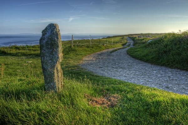 A stone pillar in a field on the river bank