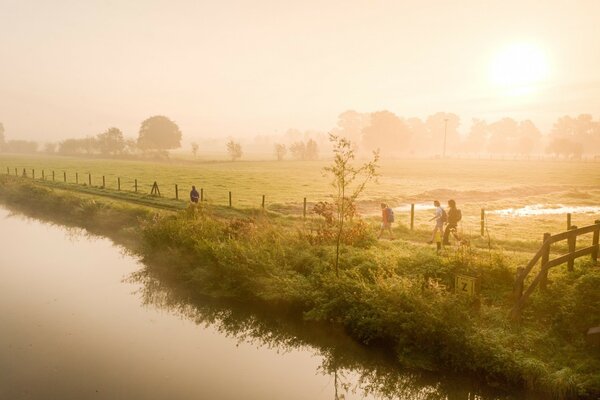 People walk along the water