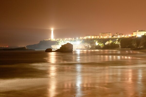 Vista de las luces de la ciudad desde la orilla del mar