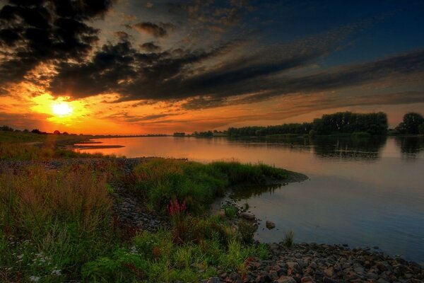 Fiery sunset on the background of the river