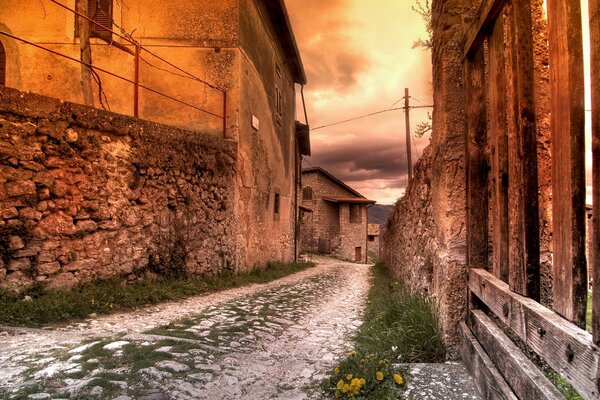 Paved old road among red buildings