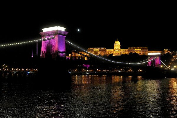 Lanterna illuminata e città sullo sfondo di acque scure