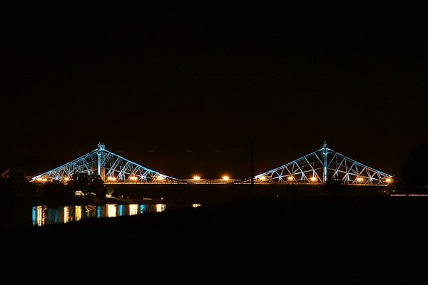 La lumière du pont dans la nuit et son reflet dans l eau