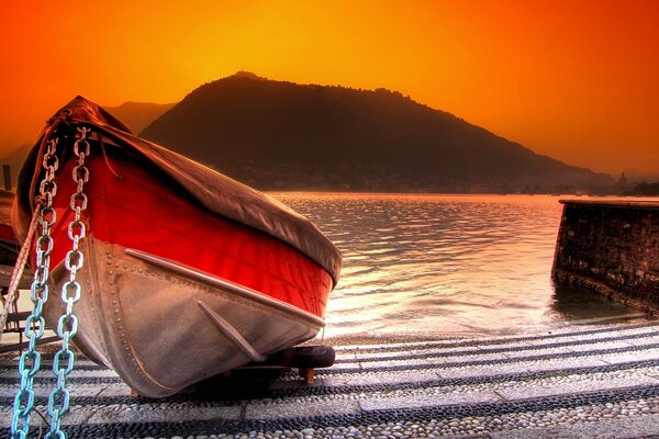 Schönes Boot am Ufer bei Sonnenuntergang