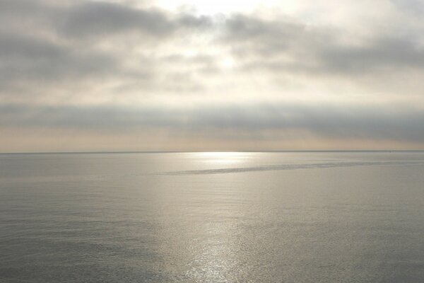 Mer lisse avec ciel nuageux