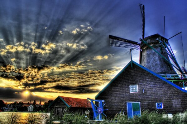 Maison et moulin à vent au coucher du soleil