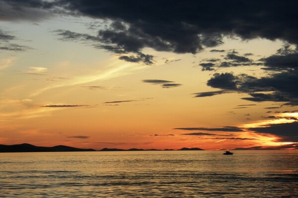 Céu do pôr do sol com nuvens acima da água