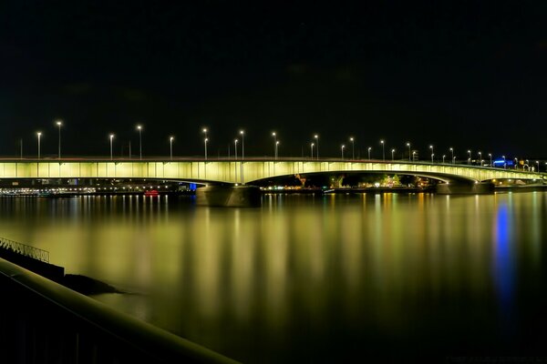 Beleuchtete Brücke über dem Wasser in der Stadt