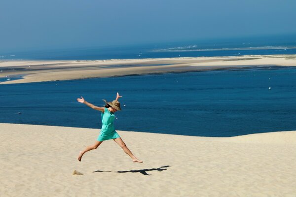 Uma menina alegre corre na areia. Férias à beira-mar