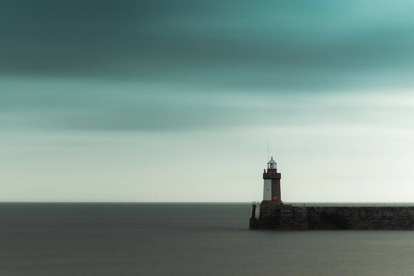 Photo with a smooth sea and a lighthouse