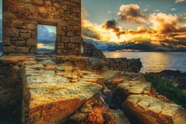 Rovine in riva al mare durante il tramonto