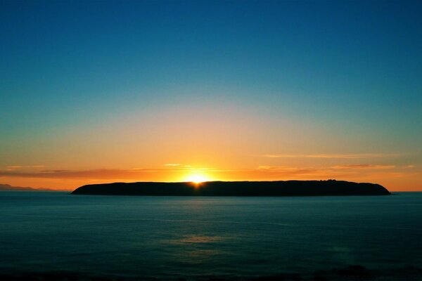 El sol sale de las montañas sobre el mar