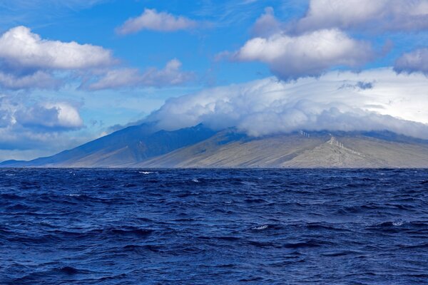 White clouds envelop the island in the sea.