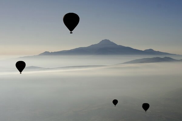 Balloons in the sky against the background of mountains