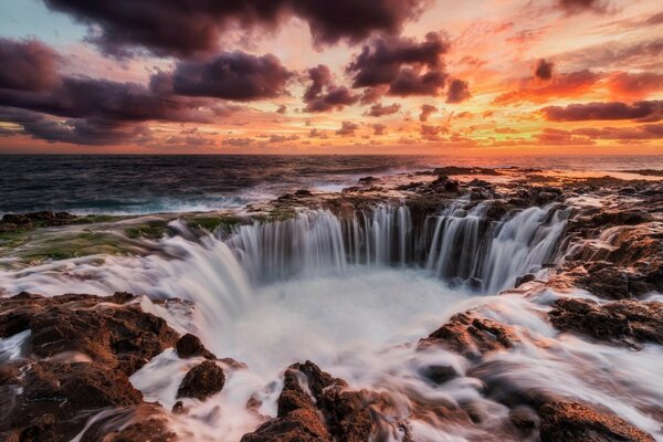 Waterfalls under a red sunset