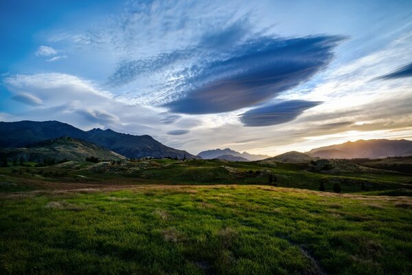 Paysage avec des nuages sombres et un champ verdoyant