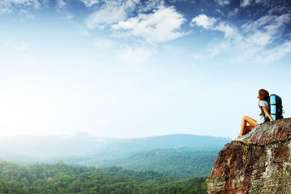 A young traveler admires the view of the sky from the mountain