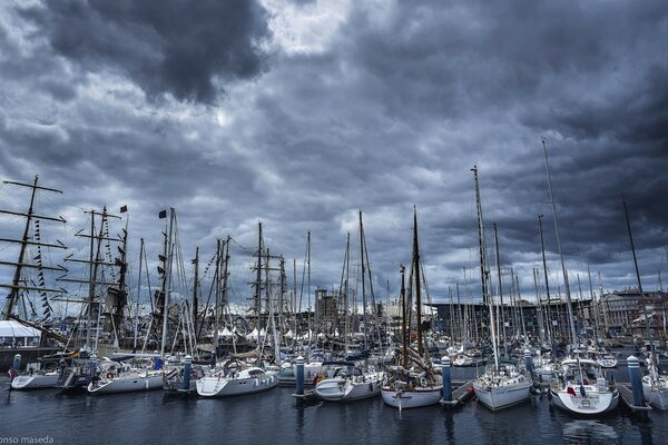 Hafen mit Yachten und Segelbooten vor dem Hintergrund des grauen Himmels