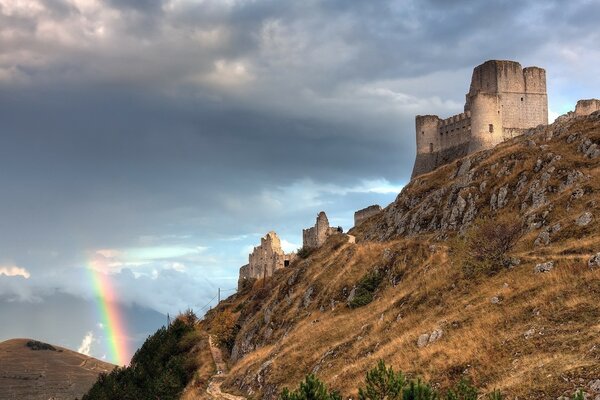 Schloss auf einem Felsen auf dem Hintergrund des Himmels mit einem Regenbogen